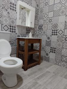 a bathroom with a toilet and a mirror and tiles at CAFOFO in Paso de los Libres