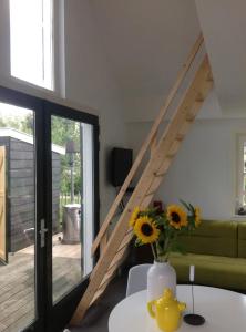 a living room with a couch and a table with flowers at Tiny house Watergang in Watergang