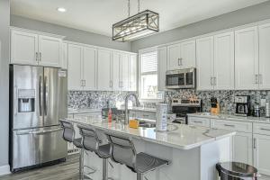 a kitchen with white cabinets and a stainless steel refrigerator at Sunset Valley in Kirk O'Cliff