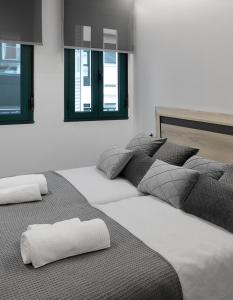 three beds are lined up in a room at El Rincón de la estación in Ourense