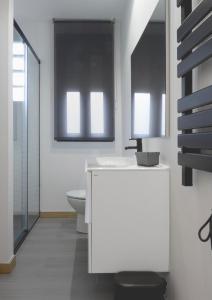 a bathroom with a white sink and a toilet at El Rincón de la estación in Ourense