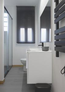 a bathroom with a white sink and a toilet at El Rincón de la estación in Ourense +26 photos