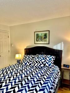 Schlafzimmer mit einem Bett mit einer blauen und weißen Bettdecke in der Unterkunft Ogunquit Downtown Apartment in Ogunquit