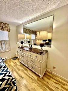 ein Schlafzimmer mit einer Kommode und einem großen Spiegel in der Unterkunft Ogunquit Downtown Apartment in Ogunquit