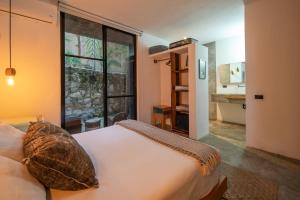 a bedroom with a bed and a large window at Tropicalito Villa on the Beach in Tulum