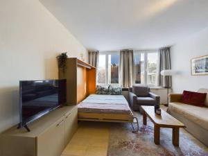 a living room with a large flat screen tv at Studio - central, calme et bien placé in Brussels