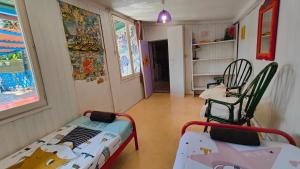 a room with a bed and two chairs in it at La Maison Mosaic Medoc - Gîtes in Gaillan-en-Médoc