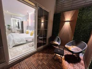 een balkon met 2 stoelen en een bed in een slaapkamer bij ‏Riyadh Almajidiya Studio in Riyad