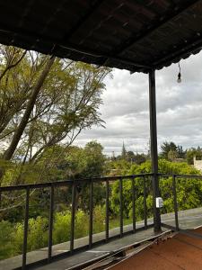 een veranda met een hek en uitzicht op een veld bij Suite Puembo Bella Stella in Quito