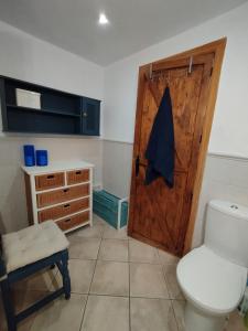 a bathroom with a toilet and a wooden door at Casa Altuna in Pinos Genil