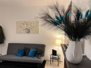 sala de estar con sofá y jarrón con plumas en Terry's House, en Casamassima