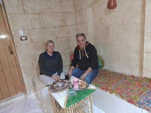 two people sitting in a room with a table at Queen House in Aswan