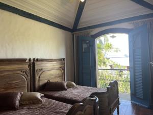 a bedroom with two beds and an open door at Historical Mansion in Pampulha in Belo Horizonte