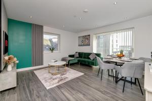 ルートンにあるPREMIUM AIRPORT SUITE~Free Parking~LUXURY Condition~BALCONY~FANTASTIC Location Close To Train Station & Town Centreの緑のソファとテーブルのあるリビングルーム