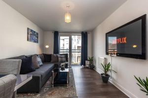 a living room with a couch and a flat screen tv at Apartment in Ashford 2 Bedroom private parking for contractors, families & holiday in Kennington