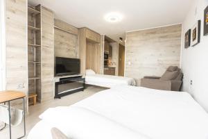 een hotelkamer met twee bedden en een televisie bij Apartamento Atlas in Sierra Nevada