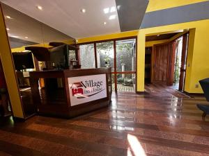 彼得罗波利斯Village Hostel的带电视的客厅和铺有地板的大堂。