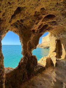 a view of the ocean through a rock cave at 21 on Pescadores T2 in Carvoeiro +6 photos