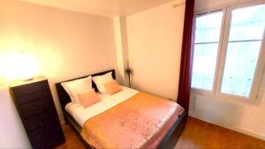 een slaapkamer met een bed met een lamp en een raam bij Appartement Familial pour 6 adultes et 5 enfants à 10 min de Disney in Bailly-Romainvilliers