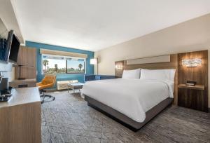 ein Hotelzimmer mit einem Bett und einem Schreibtisch in der Unterkunft Holiday Inn Express San Diego South - National City, an IHG Hotel in National City