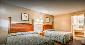 a hotel room with two beds and a mirror at Economy Hotel Memphis in Memphis