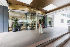 a woman walking in front of a shopping mall at Crowne Plaza Canberra by IHG in Canberra +145 photos