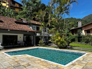 uma piscina em frente a uma casa em Village Hostel em Petrópolis