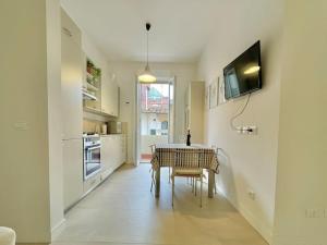 a kitchen with a table and a tv on a wall at Appartamento San Iacopino in Florence