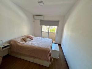 una piccola camera con letto e finestra di Hermoso y grande departamento, ubicación ideal a Rosario