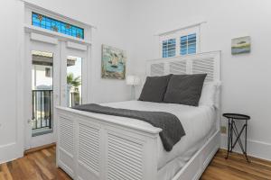 a white bed in a white room with windows at Emerald View on 30A in Santa Rosa Beach