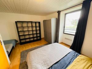 Habitación pequeña con cama y ventana en Maison au calme pour 12 personnes, en La Chapelle-de-Brain