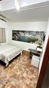 um quarto com uma cama e uma secretária. em Pousada Caminho das Cachoeiras Pirenopolis em Pirenópolis