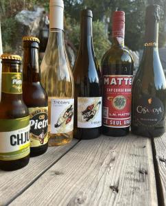 - un groupe de bouteilles de bière assises sur une table en bois dans l'établissement A Chjusella di E Sertine, à Tralonca