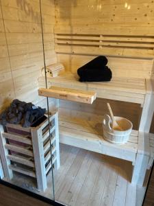 a wooden sauna with a bench and a bowl at Erwachsenenhotel BDSM Apartment Hotel Emotion Apartments mit privater Sauna & Whirlpool in Vlotho