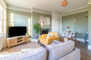 a living room with two couches and a tv at Clarence Square Penthouse 