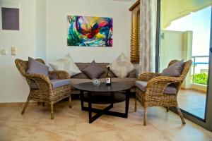 Townhouse 23, Lagada Resort في ماكري جيالوس: غرفة معيشة مع أريكة وكراسي وطاولة