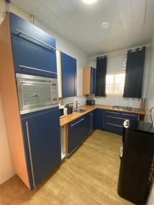 a small kitchen with blue cabinets and a sink at Kappas place HENDRIKA J VELDKAMPSTRAAT 55 in Paramaribo