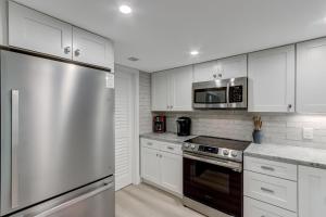 a kitchen with white cabinets and a stainless steel refrigerator at 2107 Beach Wood in Amelia Island