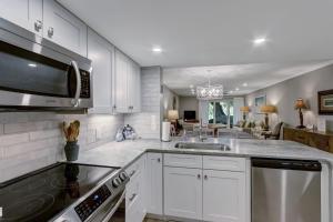 a kitchen with white cabinets and a stove top oven at 2107 Beach Wood in Amelia Island +52 photos