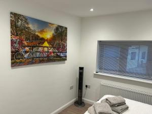 a bedroom with a painting hanging on the wall at 1 bedroom guesthouse including parking on premises in Braintree