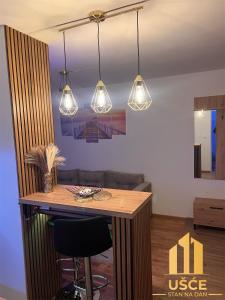 a kitchen with a bar with lights hanging from the ceiling at Apartman Ušće in Foča