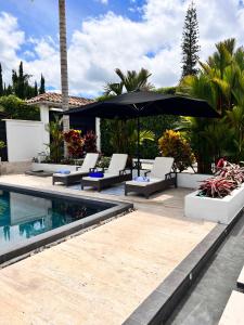 uma piscina com cadeiras e um guarda-sol ao lado de uma casa em CASA YUTE em La Tebaida