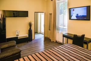 a hotel room with a bed and a television on the wall at Dům U pikové desítky in Brno