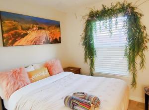 a bedroom with a bed and a window with plants at Austin Greenhouse Rentals in Austin