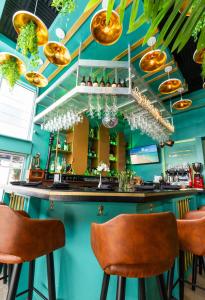 um bar com paredes azuis e bancos castanhos em Colony Hotel em Miami Beach