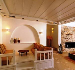 a living room with a couch and a fireplace at Themonies Luxury Suites in Chora Folegandros