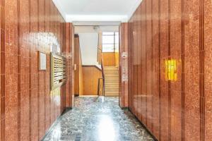 a hallway with wood paneled walls and a staircase at Casa San Paolo - Pavia Città - by Host4U in Pavia