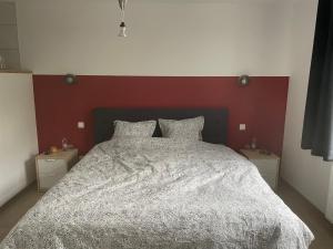 Gîte La Vieille Ferme Chaudfontaine في شو فونتان: غرفة نوم بسرير كبير مع اللوح الأمامي الأحمر
