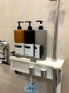 a shelf in a bathroom with three bottles on it at Clean 2 SuperSingle Beds House in Seoul
