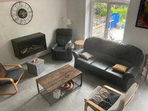 uma sala de estar com um sofá de couro e uma lareira em Gîte La Vieille Ferme Chaudfontaine em Chaudfontaine